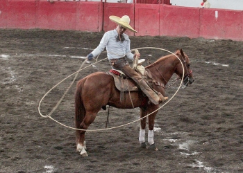 Pedro Bañuelos de Charros de Morelia "Oro" sostiene un resorte anquero durante la terna en el ruedo